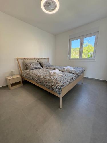a bedroom with a bed and a window at Maris Loft Šimuni in Šimuni