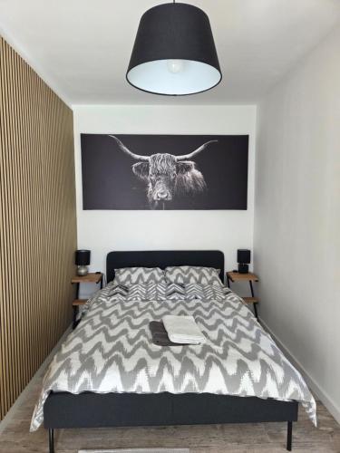 a bedroom with a bed with a picture of a bull on the wall at Apartamenty Nowielice in Nowielice