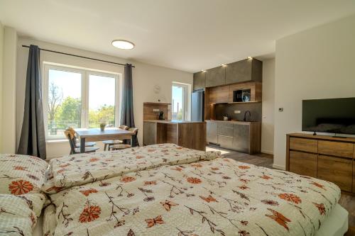 a bedroom with a bed and a kitchen with a table at Ubytování U Lesíka in Znojmo