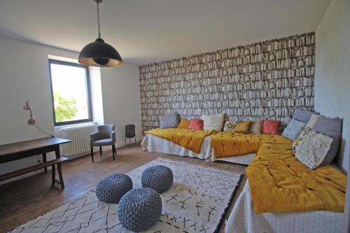 a living room with two beds and a piano at Le presbytère de thiat in Thiat