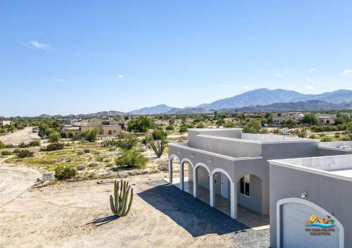 a house in the desert with mountains in the background at Casa Desert Rose - Gated Community San Felipe Vacation Rental Home in Playa Hawaii