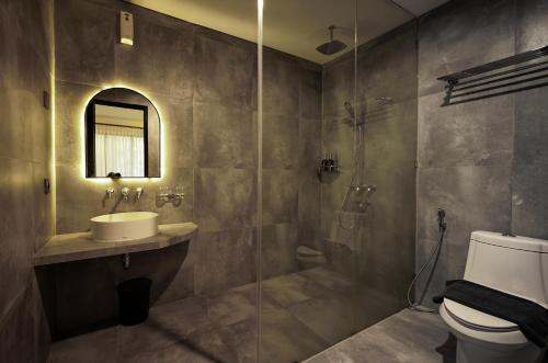 a bathroom with a toilet and a sink and a shower at Dhipa Kinanthi Prawirotaman by Raminten in Timuran