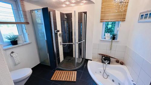 a bathroom with a shower and a tub and a toilet at Dora Design House in Człuchów