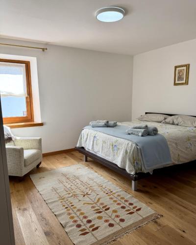 a bedroom with a bed and a chair and a rug at Casa Borgovillanuova in Laggio