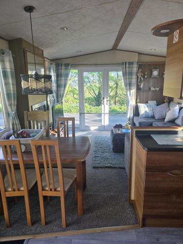 a kitchen and living room with a table and a couch at Duck Creek at Beacon Fell View in Longridge