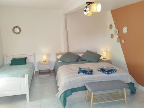 a bedroom with two beds and a table and lights at Ô pré de ma fleur in Brévonnes