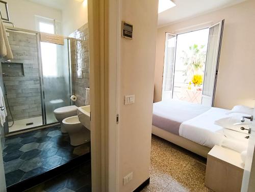 a bedroom with a bed and a bathroom with a shower at Hotel Villa Bianca in Laigueglia