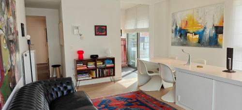 a living room with a black couch and a table at Zeebrugge Sea View, Family-Friendly & the Beach! in Zeebrugge