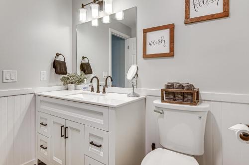 a white bathroom with a toilet and a sink at Cozy Bartlett Condo: 1 Mi to Attitash Ski Resort! in Bartlett