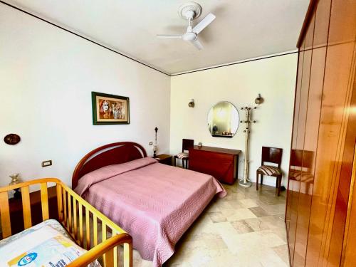 a bedroom with a bed and a crib and a mirror at CasaEolia Golden in Canneto