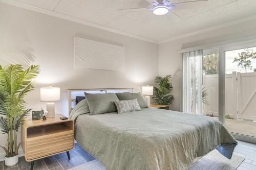 a bedroom with a bed with two lamps and a plant at < 2 Mi to Coast: St Pete Beach Gem w/ Pool Access in St. Pete Beach