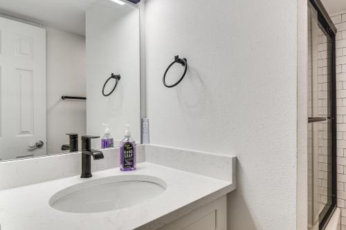 a white bathroom with a sink and a mirror at < 2 Mi to Coast: St Pete Beach Gem w/ Pool Access in St. Pete Beach