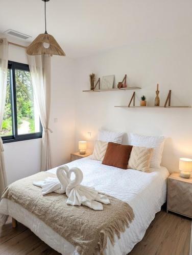 a bedroom with a white bed with a swan on it at Jardin de Sévigné à Grignan in Grignan