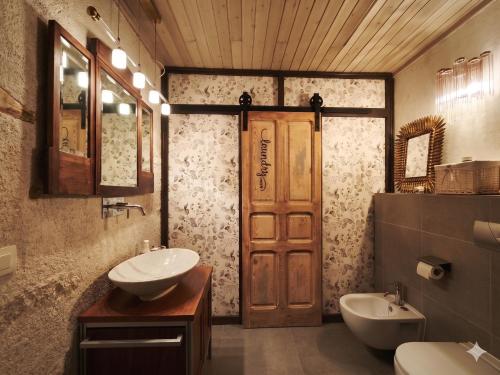 a bathroom with a sink and a toilet and a door at Casa rural con piscina cubierta en Segovia - Viento de Ladera in Segovia