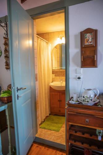 a bathroom with a shower and a sink and a mirror at Olive Cottage in Skopelos Town