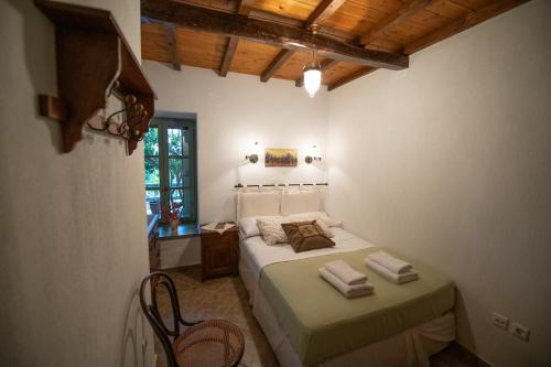 a bedroom with a bed and a table and a window at Olive Cottage in Skopelos Town