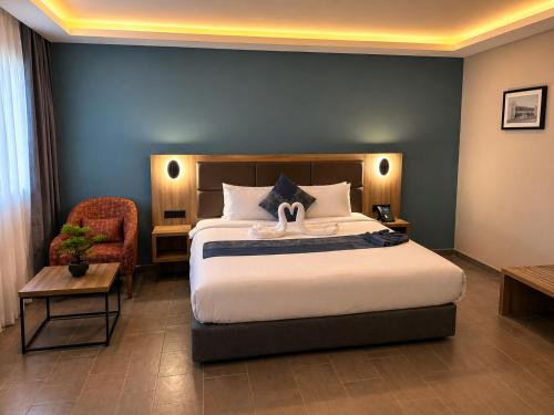 a hotel room with a bed and a chair at Delight Premium Hotel in Djibouti