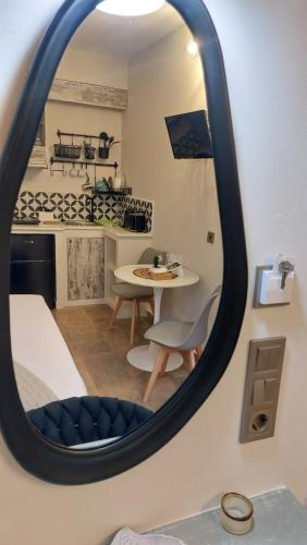 a mirror reflecting a room with a table and a kitchen at NESTOR LUXURY Studios in Vathi