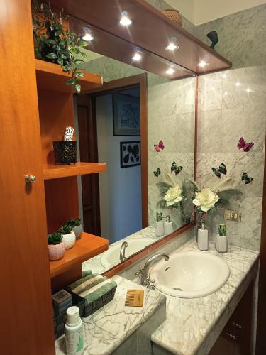 a bathroom with a sink and a large mirror at Le Petite Maison in Andria