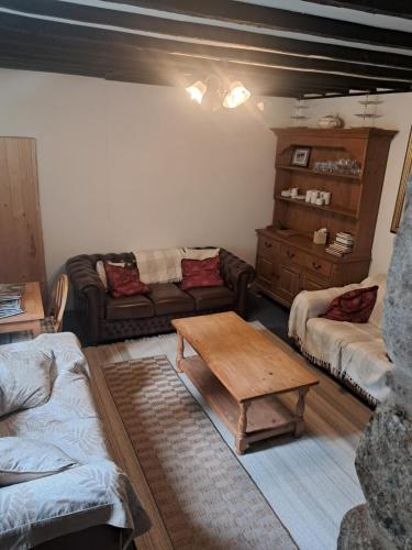 a living room with a couch and a coffee table at Beechwood Farmhouse in Yelverton