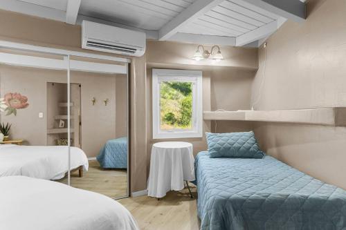 a bedroom with two beds and a table and a window at 9 Minute Drive to the Lake in Chelan