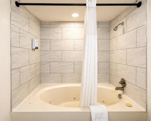 a bathroom with a bath tub with a shower at Carriage House Inn in Branson