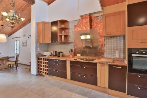 a large kitchen with wooden cabinets and a table at Longe 17 - élégante propriété avec deux maisons in Longeville-sur-Mer