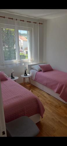 a bedroom with two beds and a window at Apartment Nona - Center, 150 meters from the beach in Supetar
