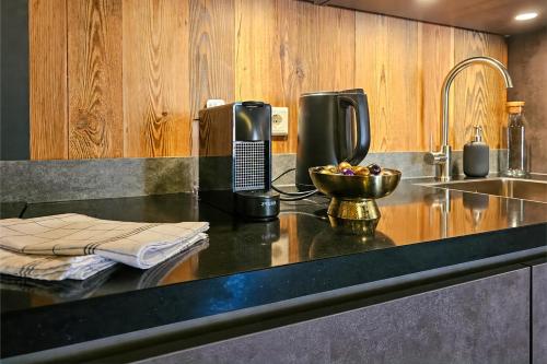 a kitchen counter with a phone and a bowl of fruit at Stylish Loft Apartment with Mountain View near the Lake in Afritz