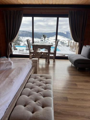 a living room with a bed and a table with a view at Vysche Neba in Bukovel