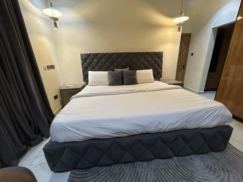 a bedroom with a large bed with white sheets at Tombell Homes in Ibadan