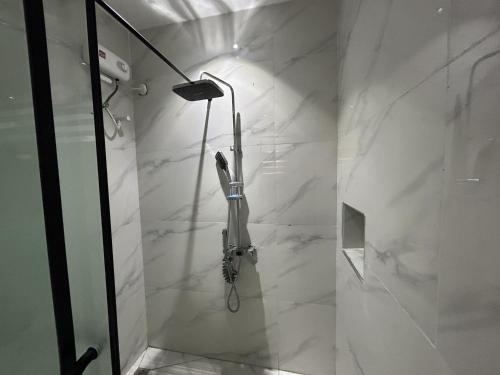 a bathroom with a shower with white marble walls at Tombell Homes in Ibadan