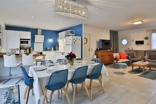 a kitchen and living room with a table and chairs at Quai Ouest - élégante maison avec piscine in Saint-Vincent-sur-Jard