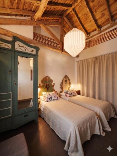 a bedroom with two beds and a chandelier at Casa rural con piscina cubierta en Segovia - Viento de Ladera in Segovia