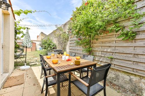 a wooden table and chairs on a patio at Maison des Surfeurs in Les Sables-d'Olonne