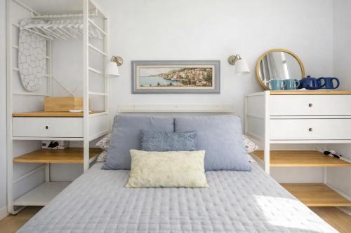 a bedroom with a bed and white shelves at Little Blue House in Marsalforn