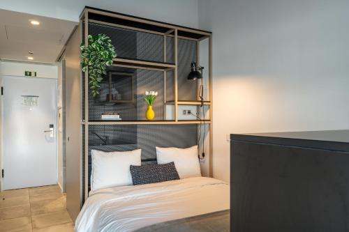 a room with a bed with a shelf above it at Codomo Living Carcavelos Lombos in Carcavelos