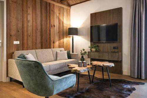 a living room with a couch and a tv at Stylish Loft Apartment with Mountain View near the Lake in Afritz