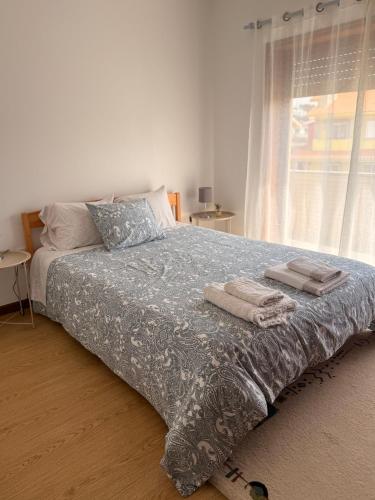 a bedroom with a bed with towels on it at Carminho beach house in Vila do Conde