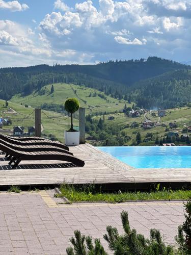 a bench next to a pool with a view of a mountain at Vysche Neba in Bukovel
