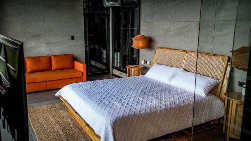 a bedroom with a bed and an orange chair at AGV II Cayo View in Monte Rojo