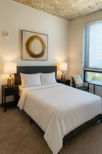 a bedroom with a large white bed and two lamps at Five Points South Spacious 2BR with 2 Queens D5 in Birmingham