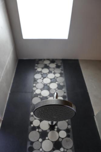 a bathroom with a black and white floor and a door at Villas H2O in Tulum