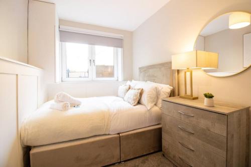 a bedroom with a bed with a mirror and a dresser at Modern 2-Bed Apartment, Greenock in Greenock