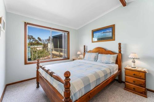 a bedroom with a bed and a large window at Spikes Place - Waterfront Serenity for Groups in Hindmarsh Island