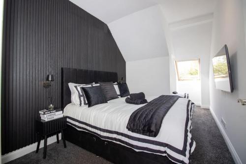 a bedroom with a large bed with a black headboard at Spacious 3-Bed Apartment, Alva, Clackmannanshire in Alva
