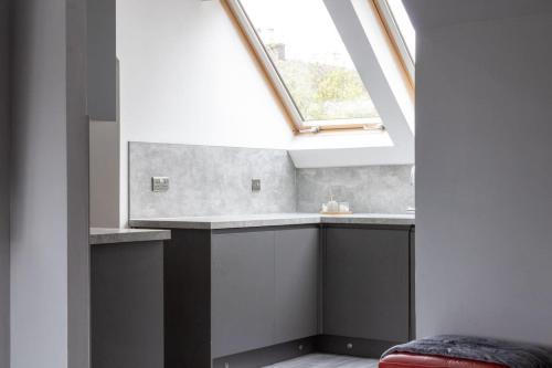 a skylight in a room with a sink and a window at Spacious 3-Bed Apartment, Alva, Clackmannanshire in Alva