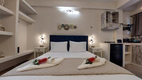 a bedroom with a large white bed with two pillows at NESTOR LUXURY Studios in Vathi