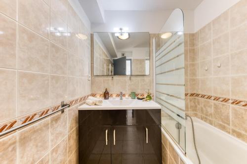 a bathroom with a sink and a mirror at Cocon lumineux au centre de Tarbes, terrasse privée au soleil, confort tout inclus in Tarbes