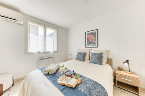 a white bedroom with two beds and a window at Cocon lumineux au centre de Tarbes, terrasse privée au soleil, confort tout inclus in Tarbes
